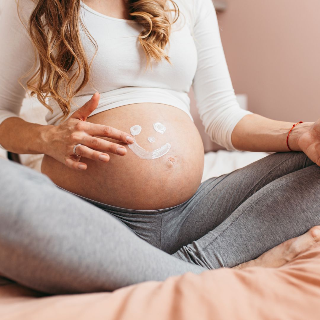 pregnancy belly with a painted on smiley face